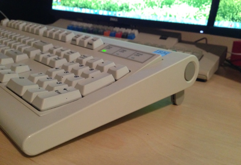 Side shot showing Model F style keyboard stand.  This one is different though-- the legs are actually spring-loaded.  If you press the buttons the legs will automatically rotate outward.